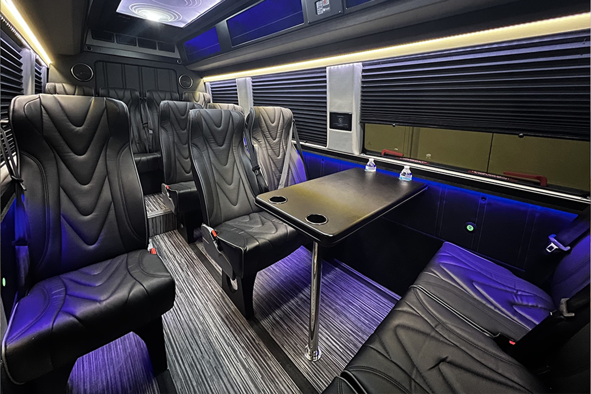 The interior of a luxury Executive Sprinter Van equipped with leather seating, ideal for group corporate transportation and mobile meetings.